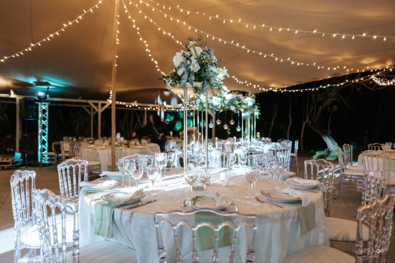 Photo d'un mariage à La Réunion – Centre de table en hauteur – Décoration florale, Chaises napoléon transparentes, Guirlandes lumineuses