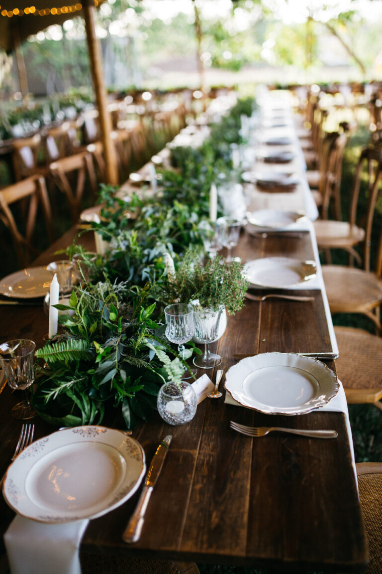 Photo d'un mariage à La Réunion – Grande tablée – Chaises crossback, Tables bois rectangulaires, Pack vaisselle mix fleurs/dorés
